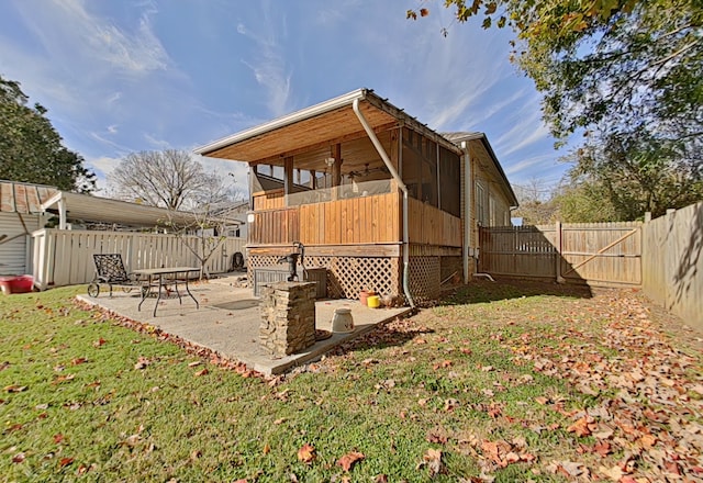 view of side of home featuring a patio, a sunroom, and a lawn