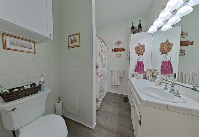 bathroom with vanity, wood-type flooring, toilet, tile walls, and radiator heating unit