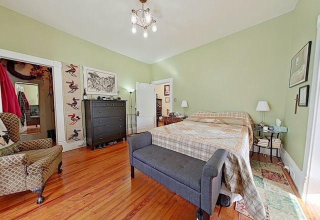 bedroom featuring a notable chandelier and light wood-type flooring