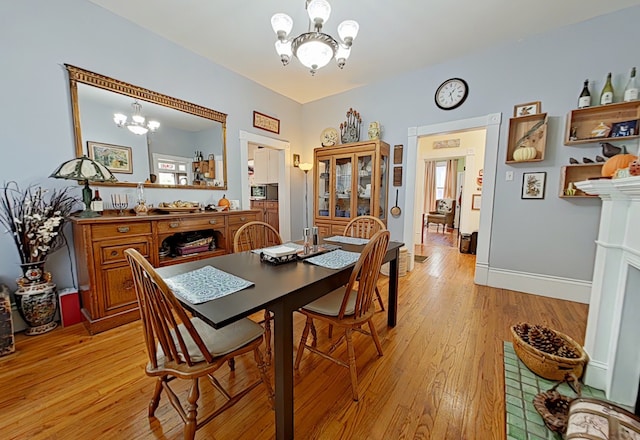 dining room featuring a chandelier, a wealth of natural light, and light hardwood / wood-style flooring