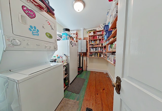 laundry room featuring hardwood / wood-style flooring and stacked washer and clothes dryer