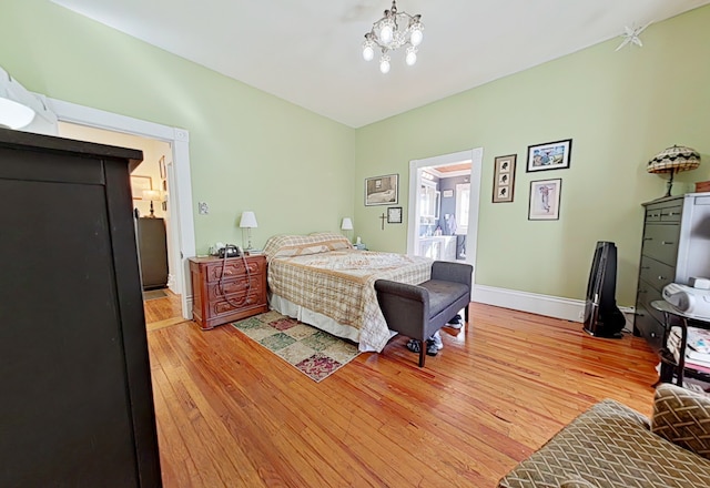 bedroom with a chandelier and light hardwood / wood-style flooring