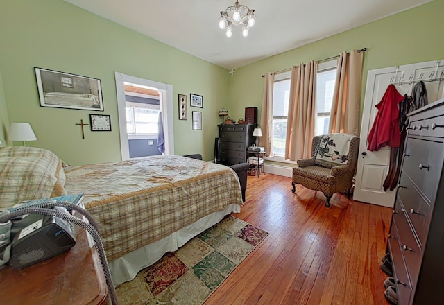 bedroom with a chandelier and wood-type flooring