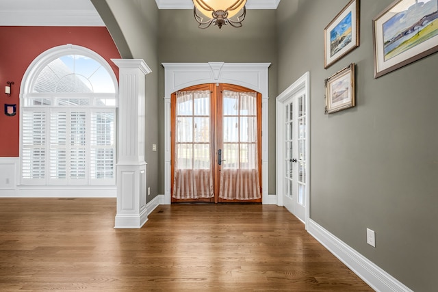 entryway featuring decorative columns, hardwood / wood-style floors, and french doors