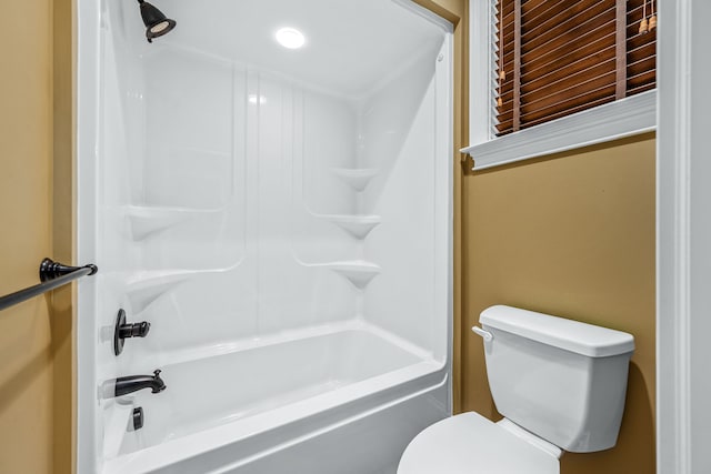 bathroom featuring washtub / shower combination and toilet