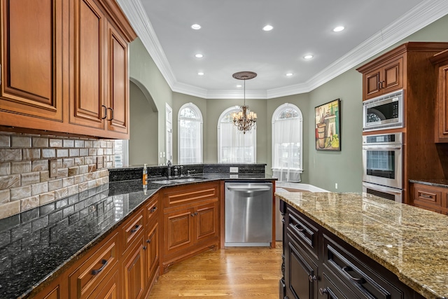 kitchen featuring dark stone countertops, sink, plenty of natural light, and stainless steel appliances