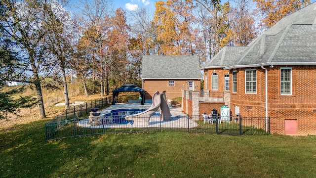 view of swimming pool featuring a patio, a water slide, and a yard