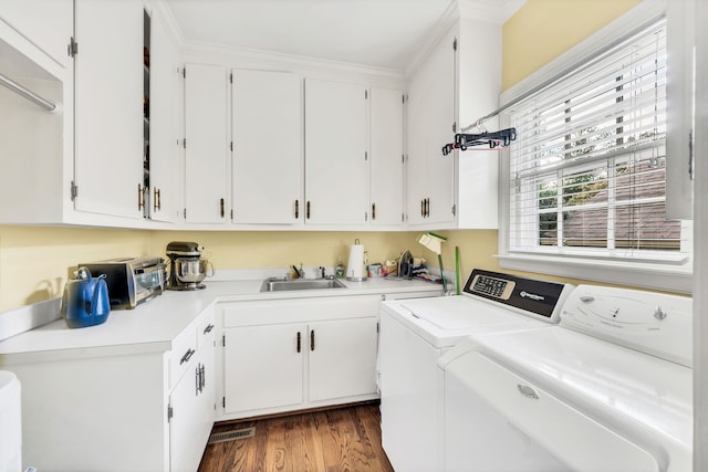 washroom featuring cabinets, sink, dark hardwood / wood-style floors, crown molding, and independent washer and dryer