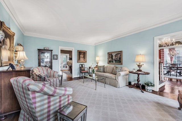 living room featuring ornamental molding, wood-type flooring, and a chandelier