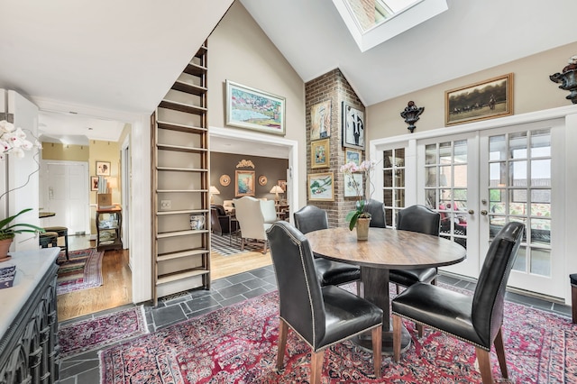 dining room with dark hardwood / wood-style floors, high vaulted ceiling, a skylight, and french doors