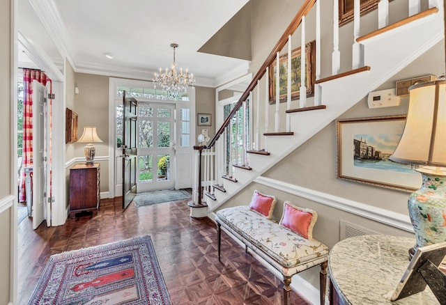 foyer featuring dark parquet floors, an inviting chandelier, and ornamental molding