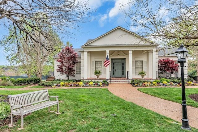 neoclassical home featuring a front lawn