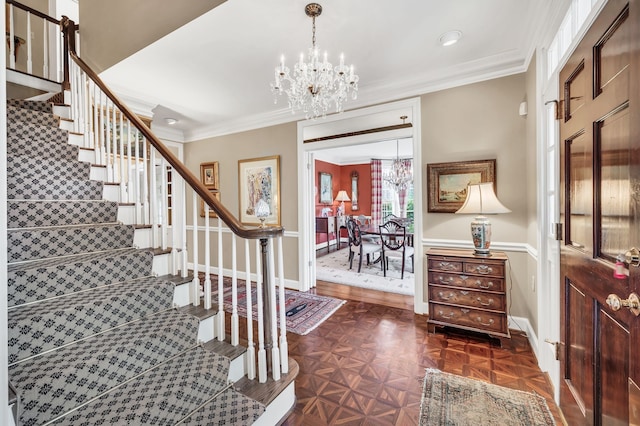 foyer entrance featuring dark parquet flooring, crown molding, and an inviting chandelier