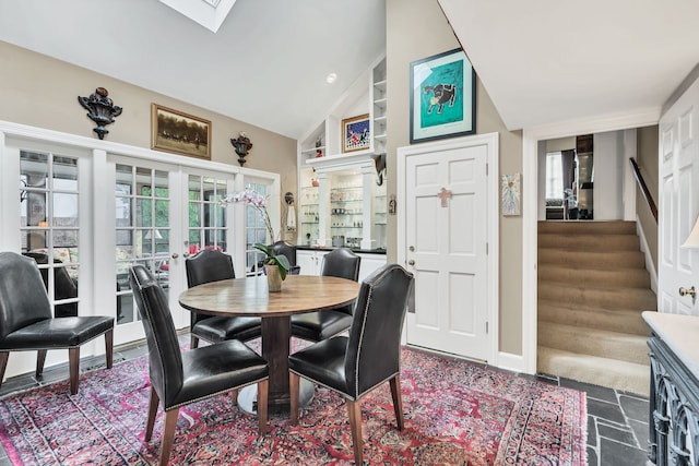 dining room with french doors, high vaulted ceiling, and a skylight