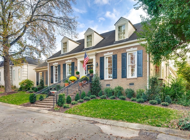 new england style home featuring a front lawn