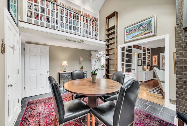 dining space with dark wood-type flooring and vaulted ceiling