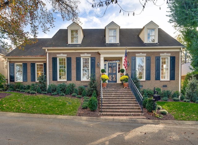 cape cod house featuring a front lawn