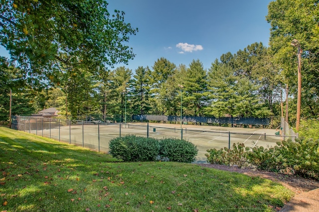 view of tennis court with a yard