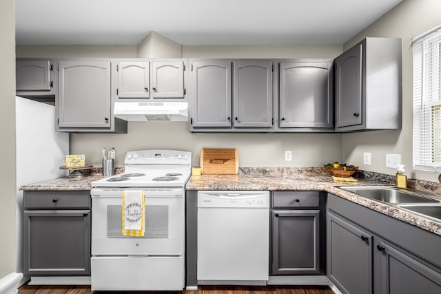 kitchen featuring white appliances, plenty of natural light, gray cabinetry, and dark hardwood / wood-style flooring