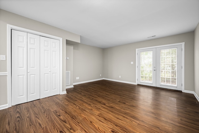 unfurnished bedroom with access to outside, french doors, dark wood-type flooring, and a closet