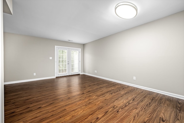 empty room featuring dark hardwood / wood-style flooring and french doors