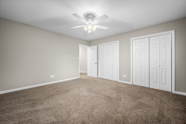 unfurnished bedroom with multiple closets, carpet floors, and ceiling fan