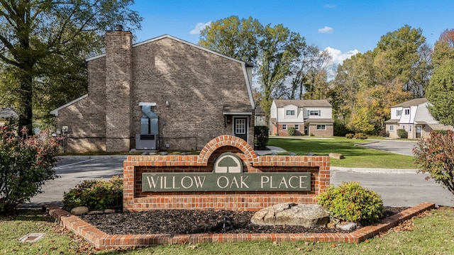 community / neighborhood sign featuring a yard