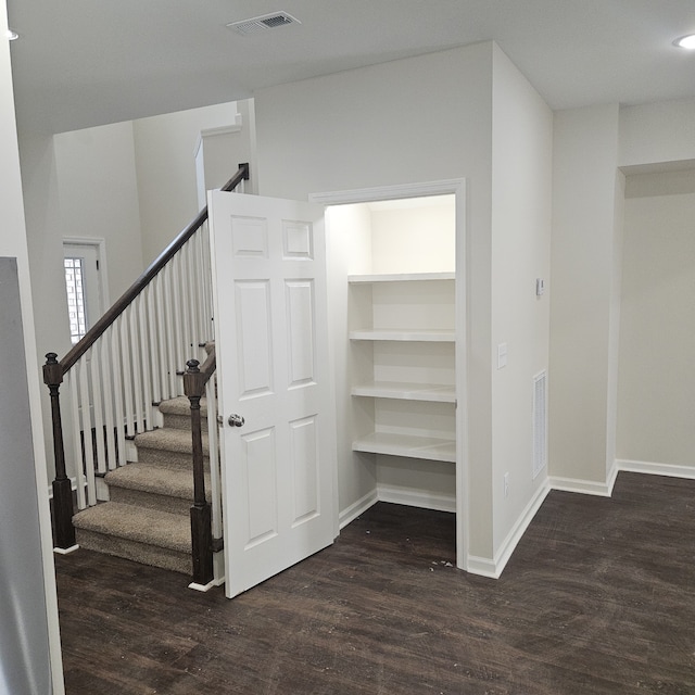 stairs featuring built in features and wood-type flooring