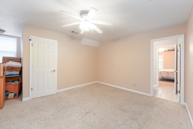 unfurnished bedroom with light carpet, ceiling fan, and ensuite bathroom