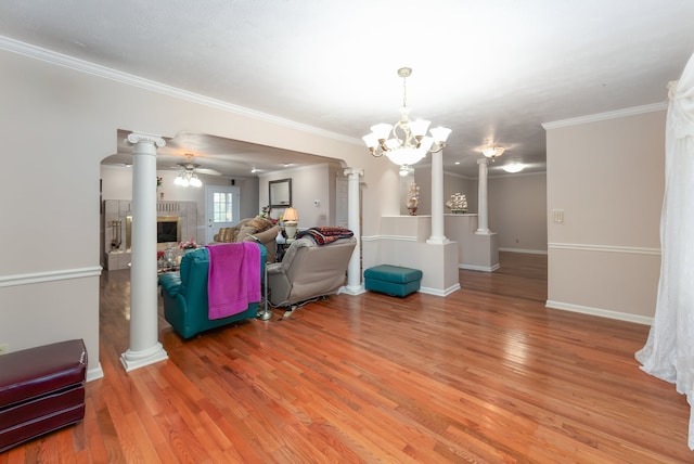 living room with ornamental molding, ceiling fan with notable chandelier, and hardwood / wood-style flooring