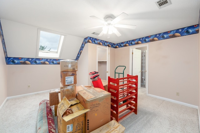 interior space with lofted ceiling with skylight, light carpet, and ceiling fan