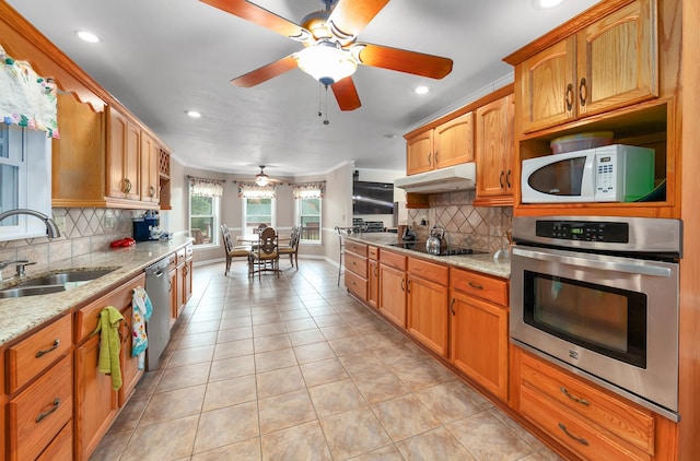 kitchen featuring light tile patterned floors, stainless steel appliances, sink, and light stone countertops