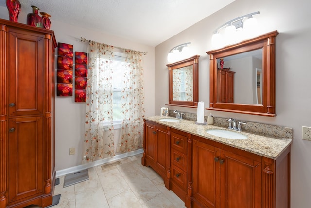 bathroom with vanity, a textured ceiling, and tile patterned flooring