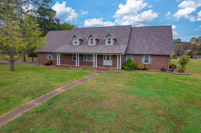 new england style home with covered porch and a front yard