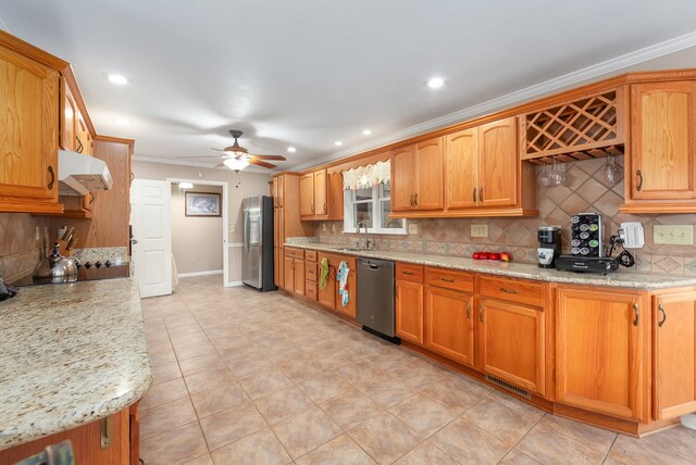 kitchen with sink, tasteful backsplash, ceiling fan, light stone countertops, and appliances with stainless steel finishes