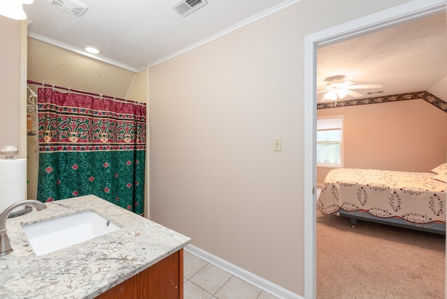 bathroom featuring lofted ceiling, tile patterned floors, ornamental molding, vanity, and ceiling fan