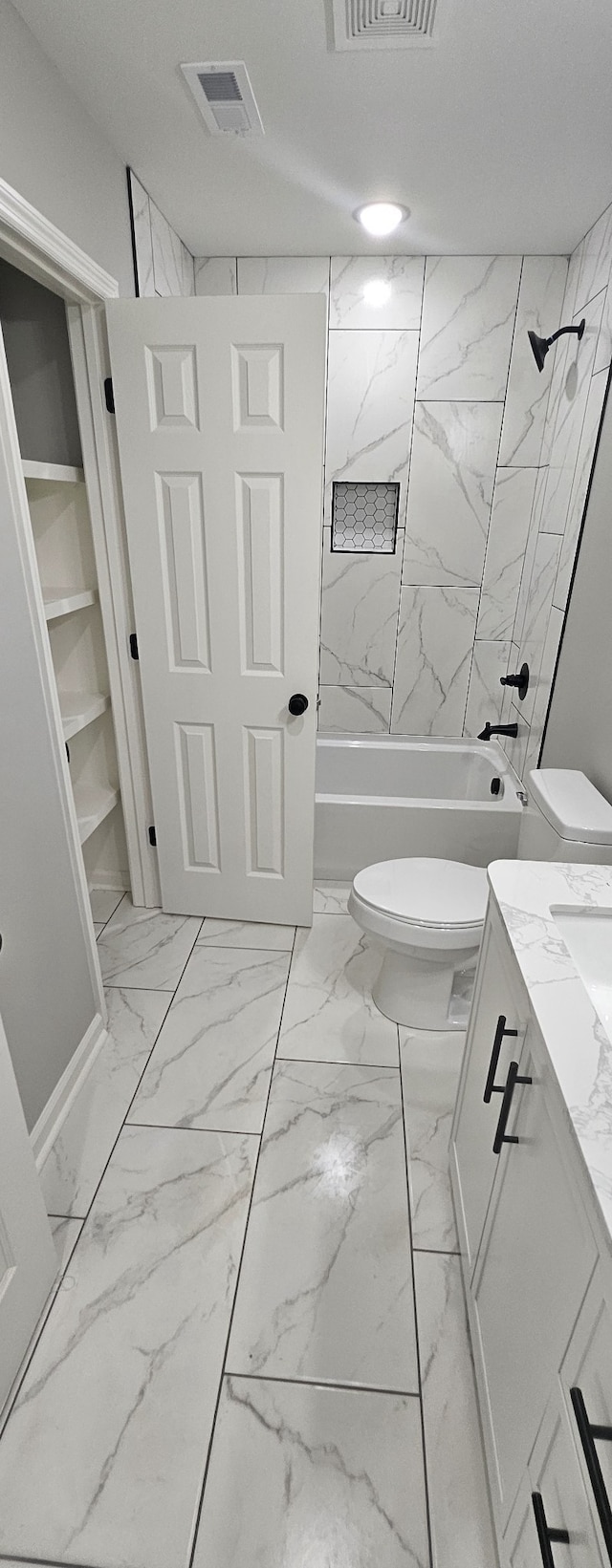 full bathroom with vanity, tiled shower / bath combo, and toilet