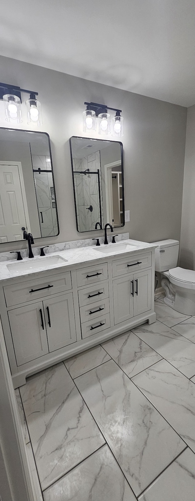 bathroom featuring vanity, toilet, and an enclosed shower