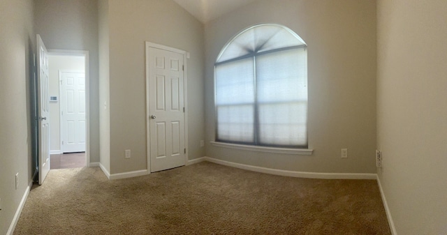 unfurnished bedroom featuring vaulted ceiling, carpet floors, and baseboards