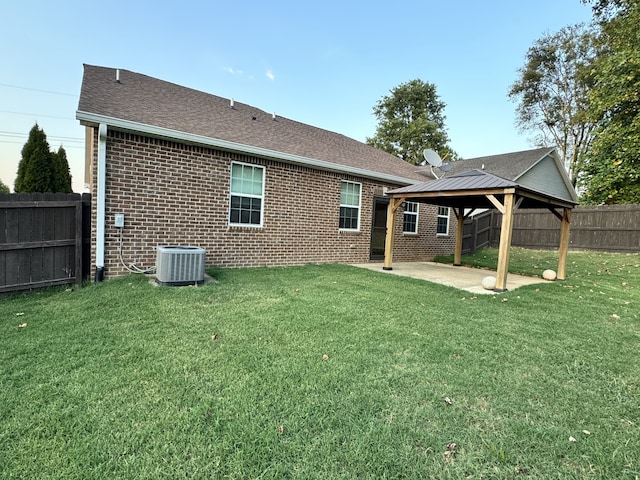 rear view of house with a patio area, central AC, brick siding, and a gazebo