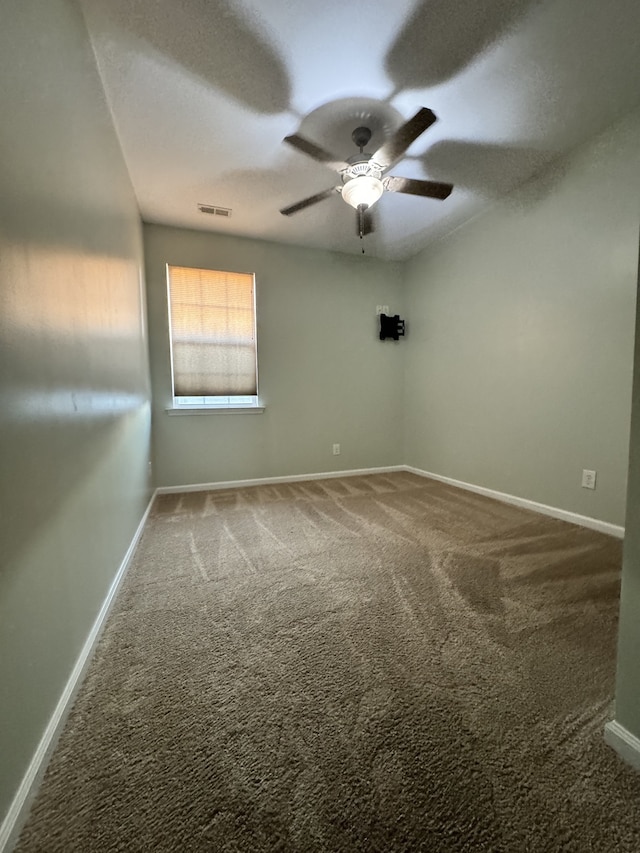 empty room with visible vents, a ceiling fan, carpet flooring, a textured ceiling, and baseboards