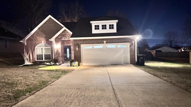 view of front of house featuring a yard, concrete driveway, and brick siding