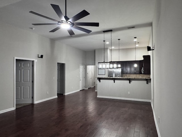 kitchen with visible vents, dark wood finished floors, stainless steel fridge with ice dispenser, a kitchen breakfast bar, and a peninsula