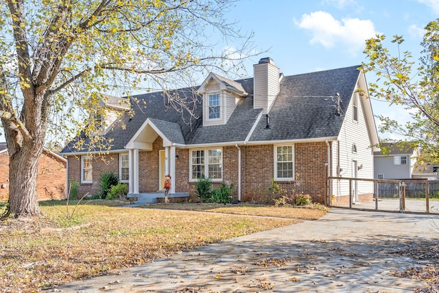 cape cod-style house with a front lawn