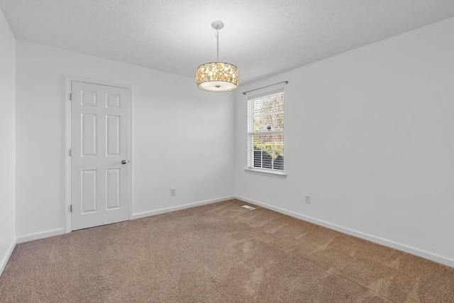 unfurnished room with carpet floors and a textured ceiling