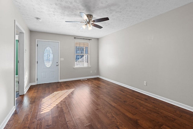 foyer featuring dark hardwood / wood-style flooring, ceiling fan, and a textured ceiling