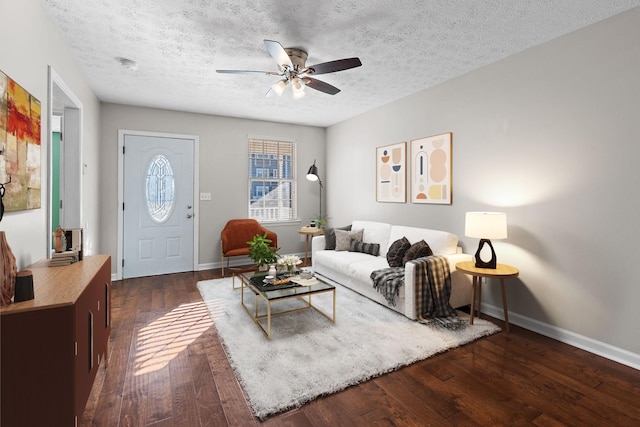 living room with ceiling fan, dark hardwood / wood-style floors, and a textured ceiling