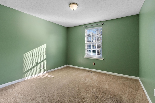 carpeted empty room featuring a textured ceiling