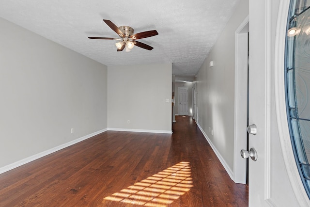 spare room featuring dark wood-type flooring, ceiling fan, and a textured ceiling