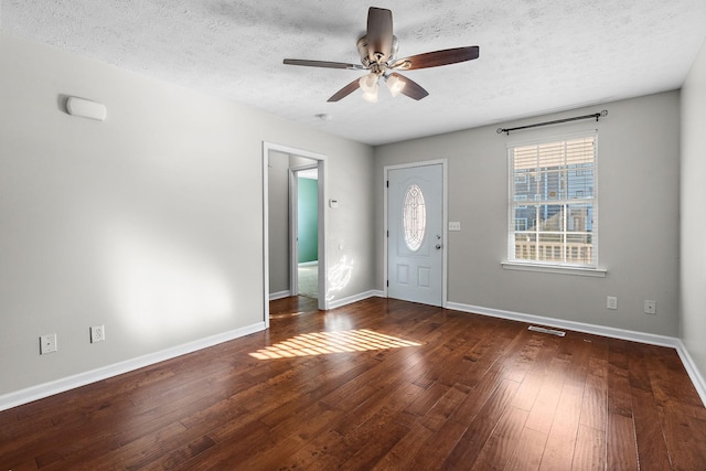 foyer featuring ceiling fan, dark wood-type flooring, and a textured ceiling